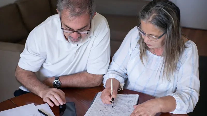 Couple qui étudie des documents financiers à la maison