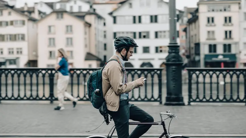 Cycliste qui traverse un pont en ville avec son vélo