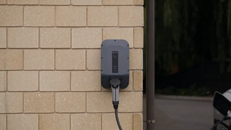 Borne de recharge murale fixée sur la façade d'une maison