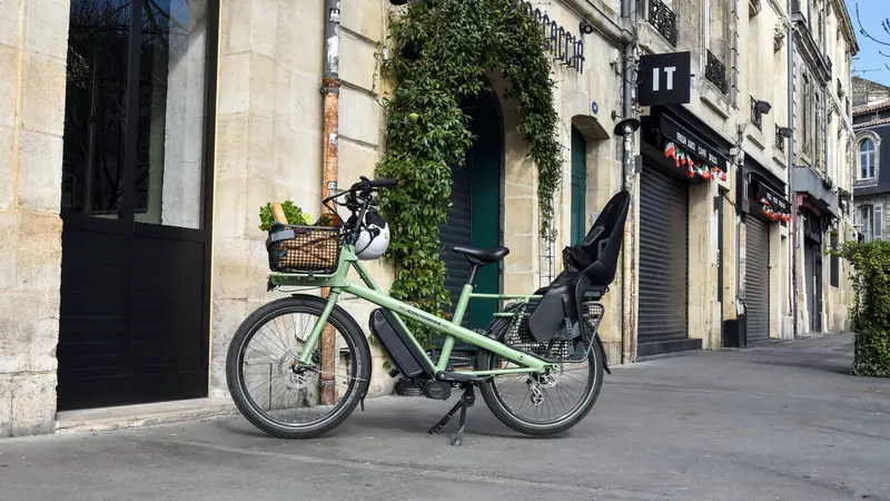 Vélo électrique avec siège enfant garé dans une rue