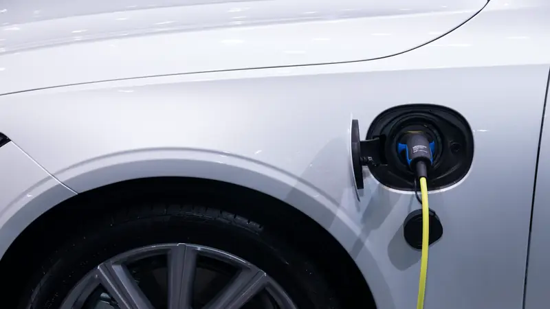 Câble de recharge branché sur une voiture blanche
