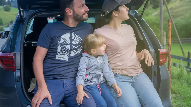 Famille en pause assise dans le coffre de la voiture
