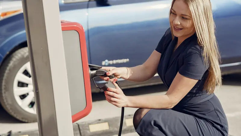 Conductrice qui branche sa voiture sur une borne de recharge