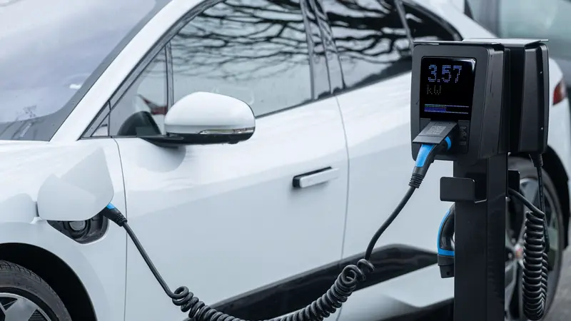 Voiture électrique branchée sur une borne avec son câble