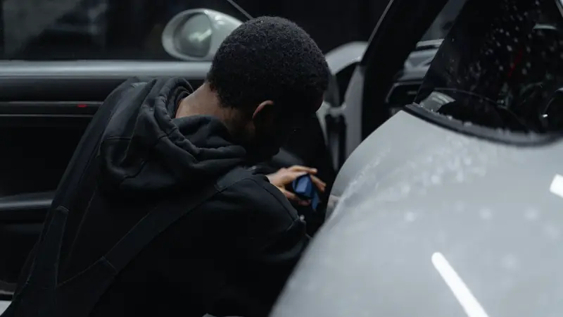 Personne penchée à l'intérieur d'une voiture